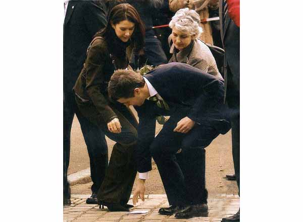 Prince Frederik of Denmark picking up the handkerchief of Princess Mary